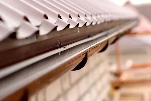 Water droplets along a covered residential gutter edge