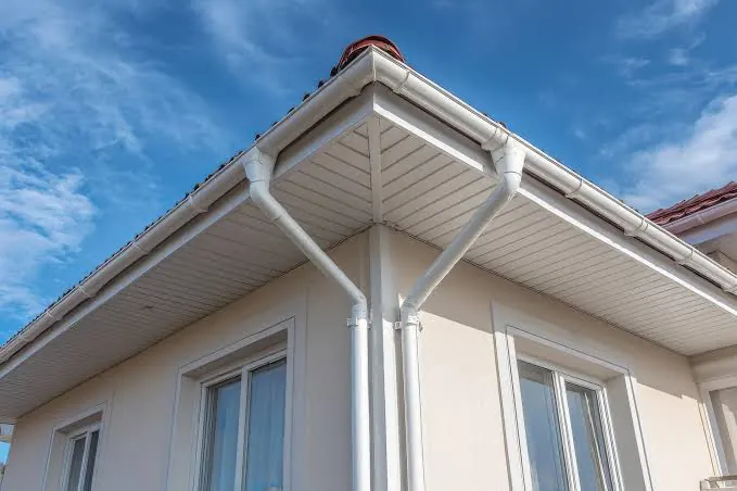 White gutters and downspout runs at a residential corner